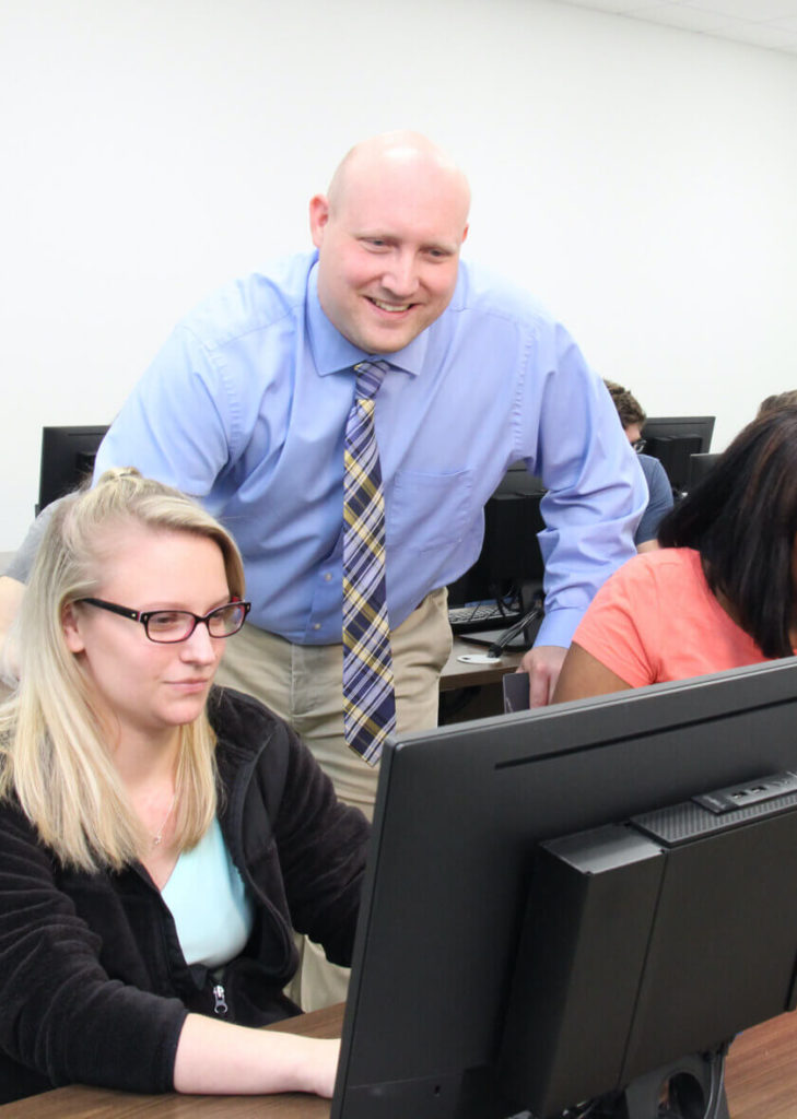 Instructor helping a technology student